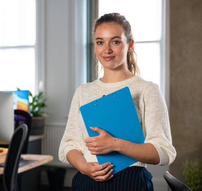 Person holding a clipboard in an office.