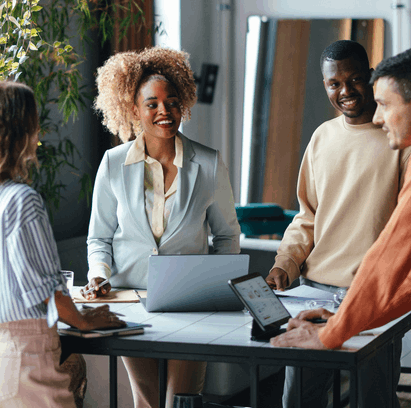 4 Employees together smiling in an office